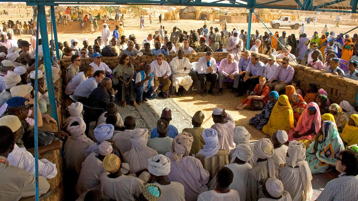 Large group of people sitting in a square all facing each other.