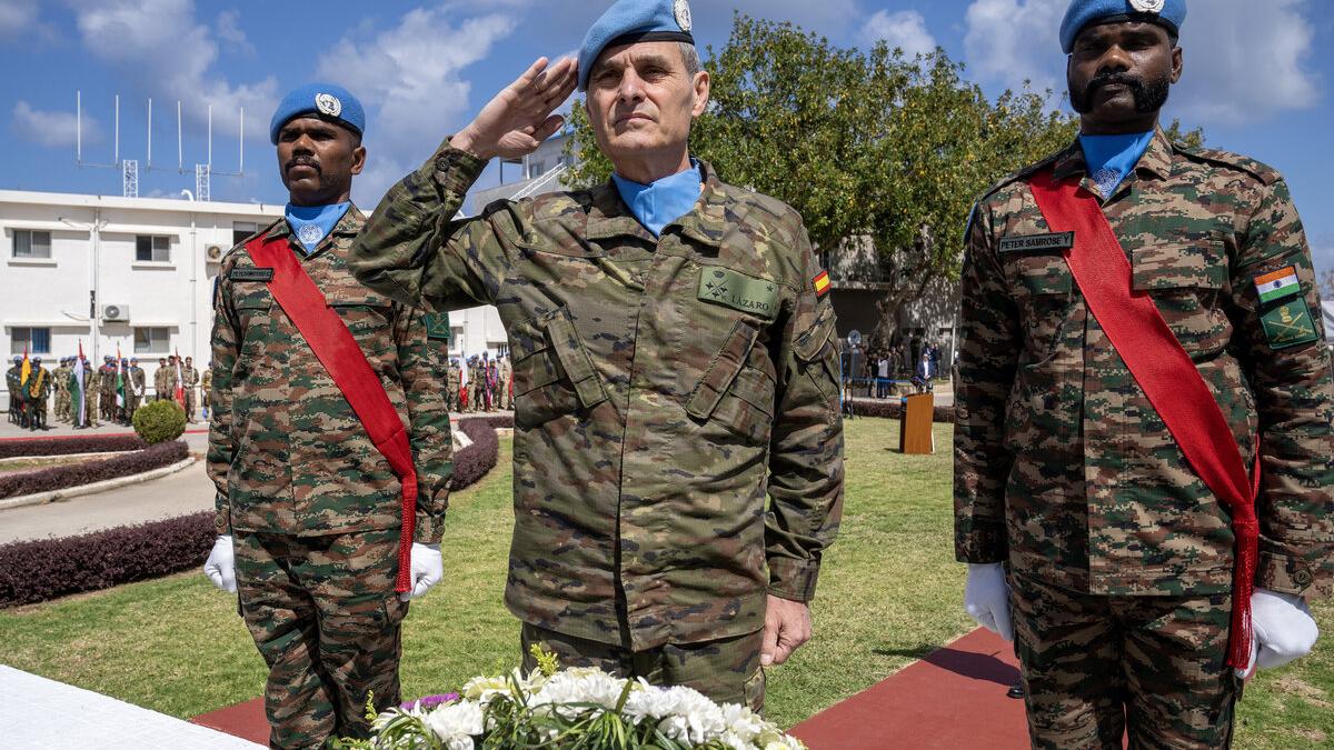 Lieutenant General Aroldo Lázaro salutes with two peacekeepers.