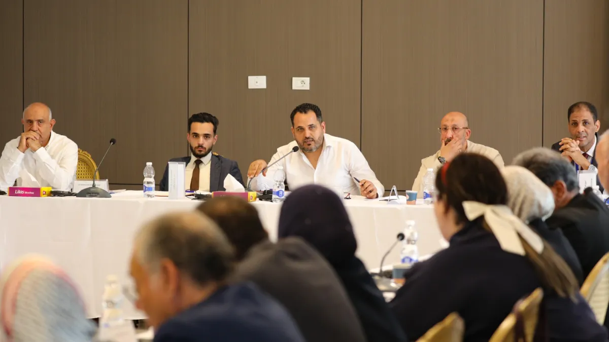 Members of the Structured Dialogue Governance Track sit around a table and discuss