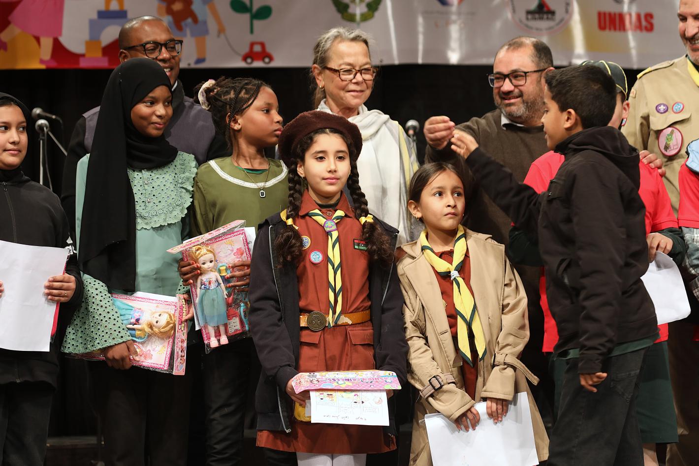 Children and men standing next to DSRSG-RC