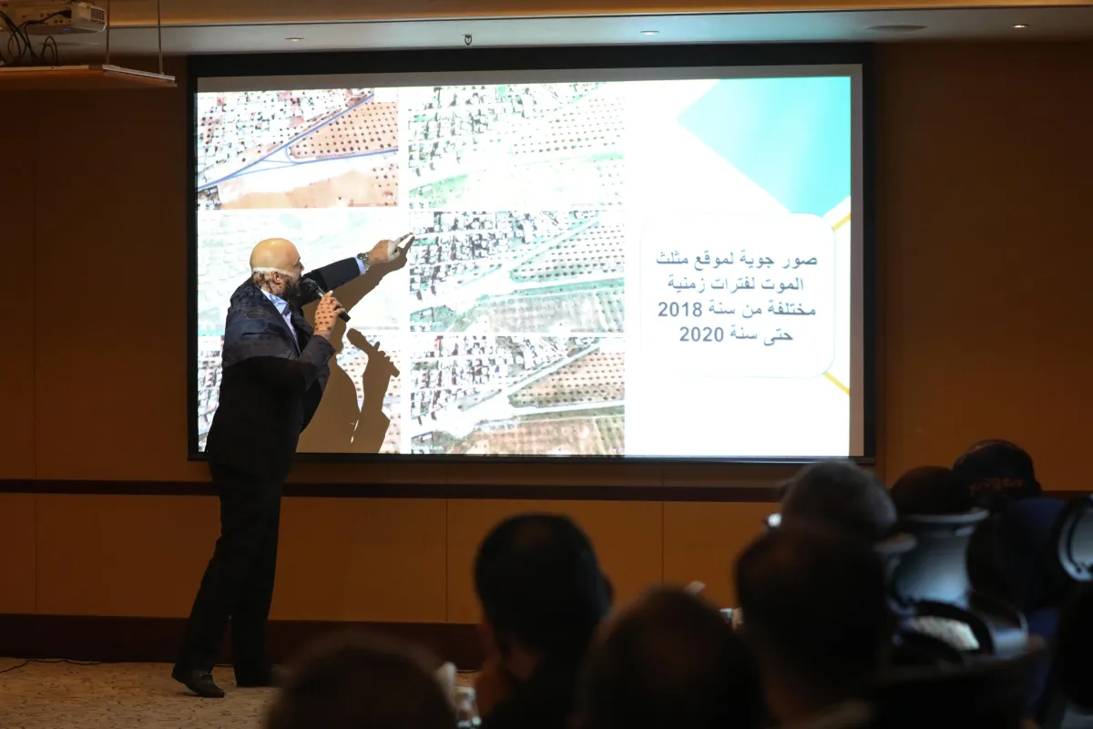 A man presenting a satellite photo for potential mass grave site